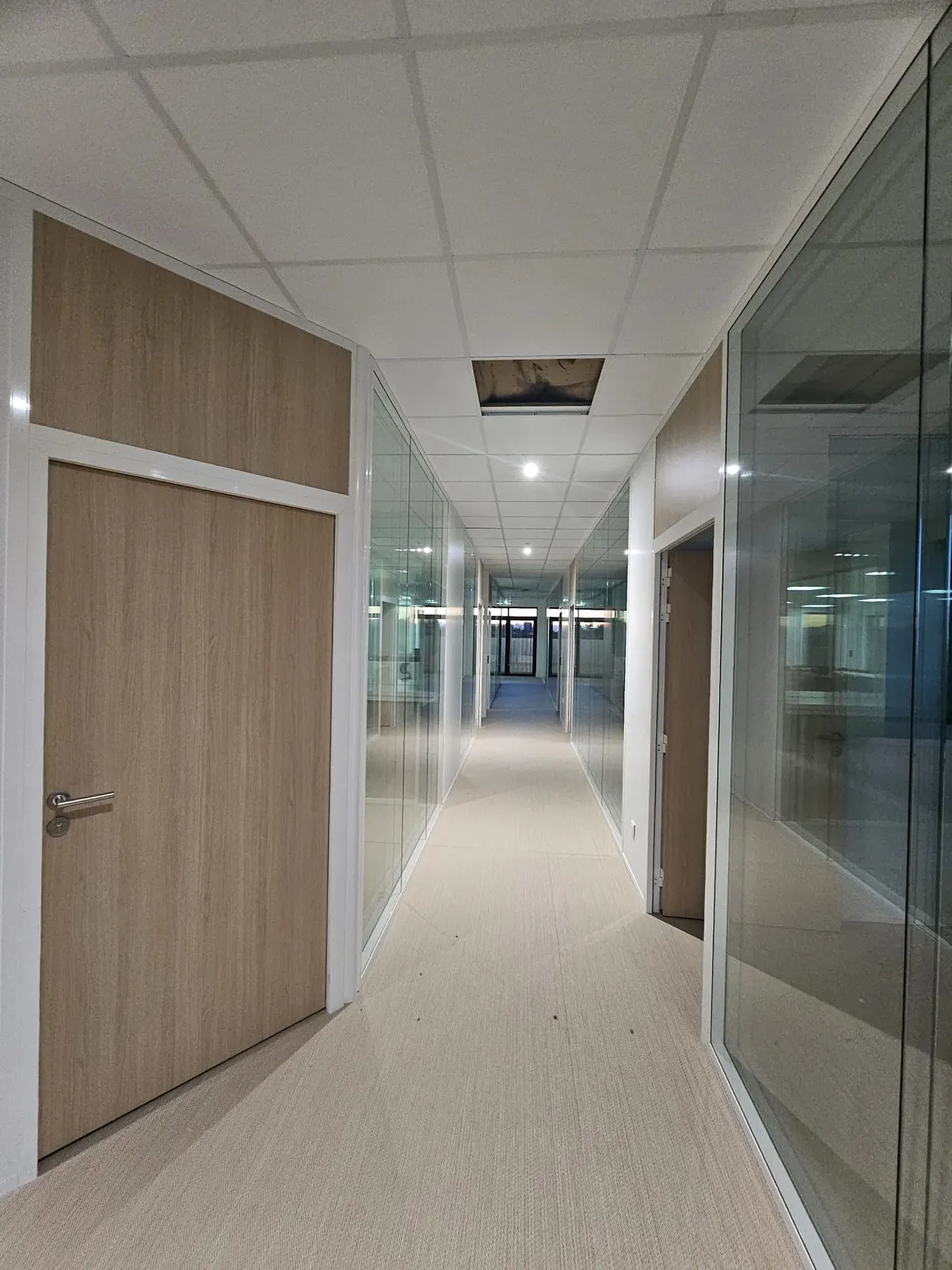 Couloir équipé de cloisons vitrées et de portes bois posées par Andrey Construction