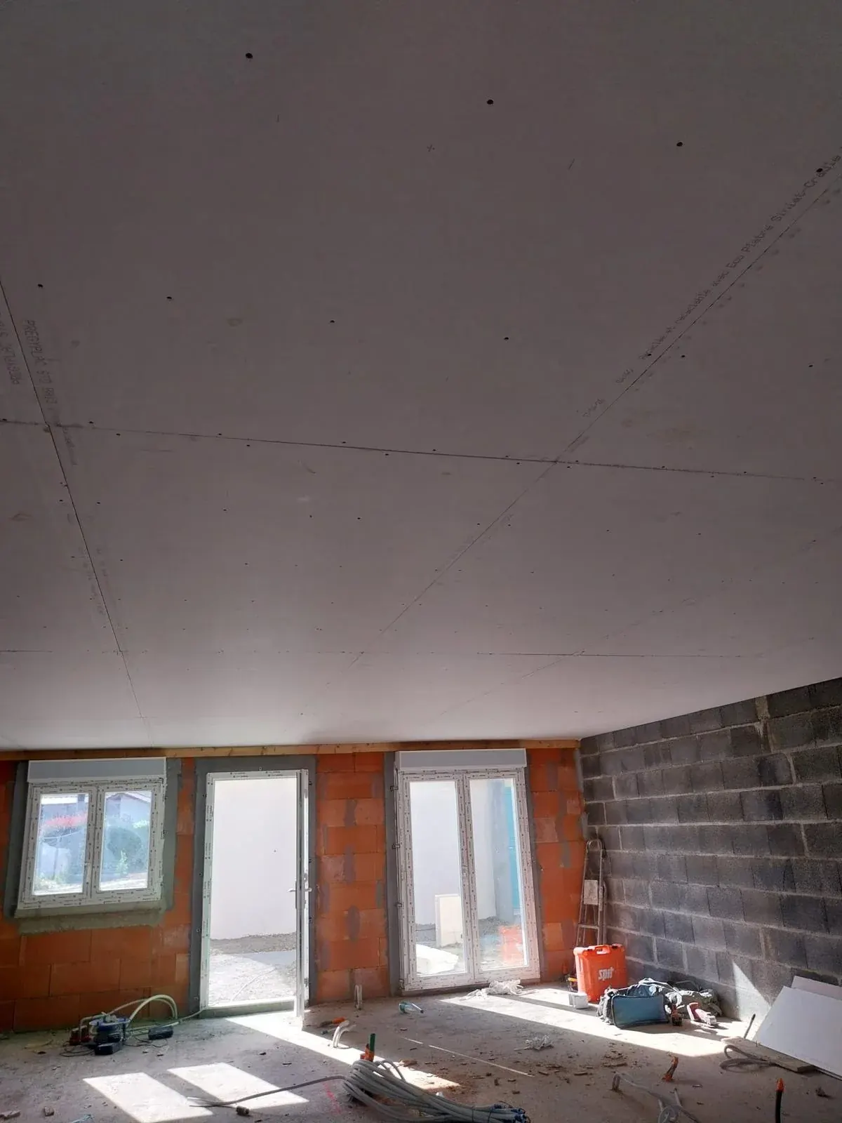 Fenêtre et porte-fenêtre PVC posées dans une pièce en rénovation